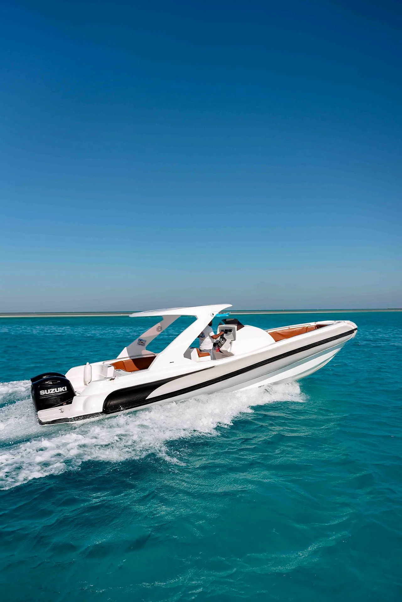 A white speedboat under way on flat turquoise water off Hurghada.