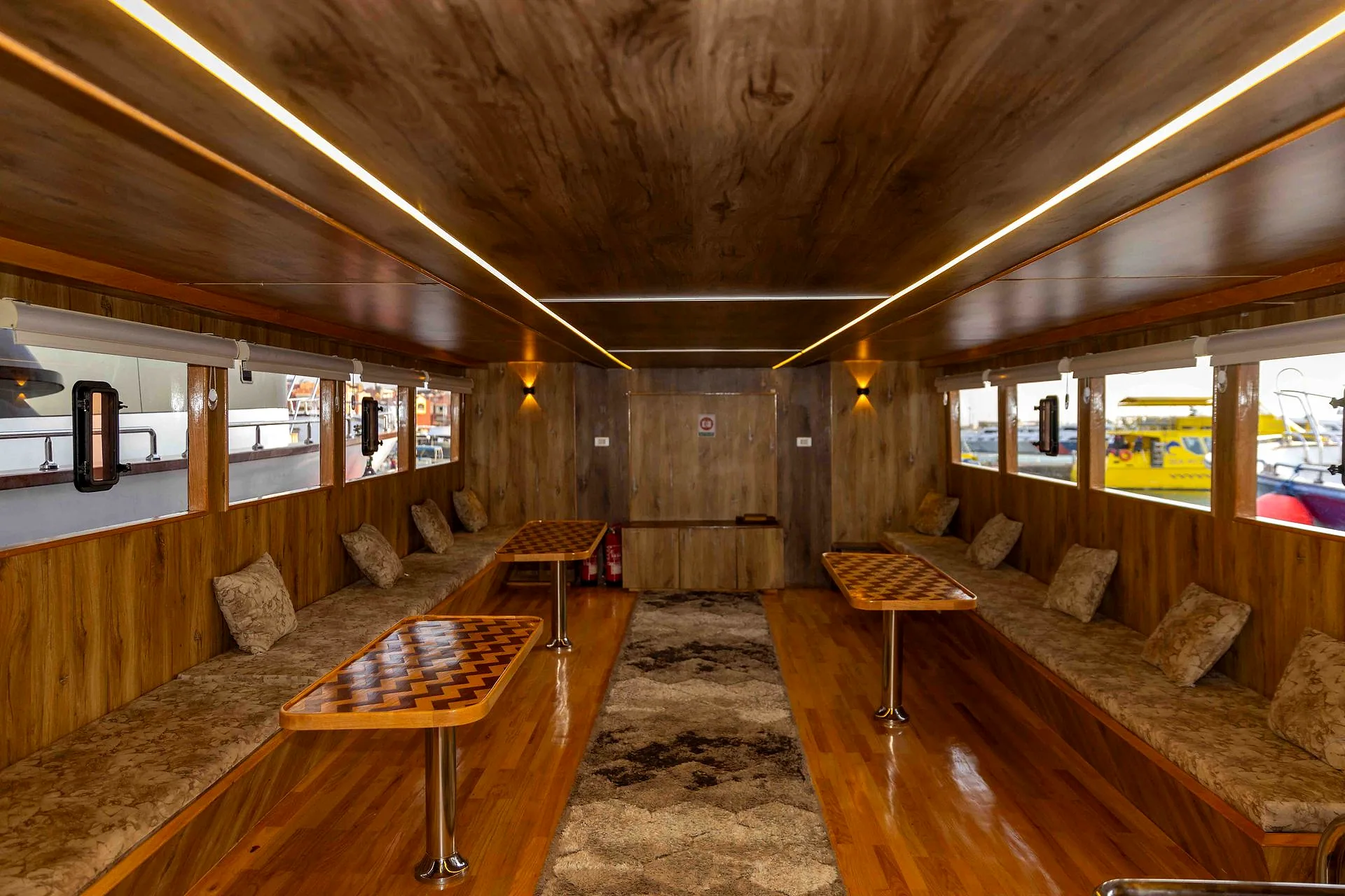 The timber-lined saloon of one of the company’s boats, with bench seating and tables along both sides.