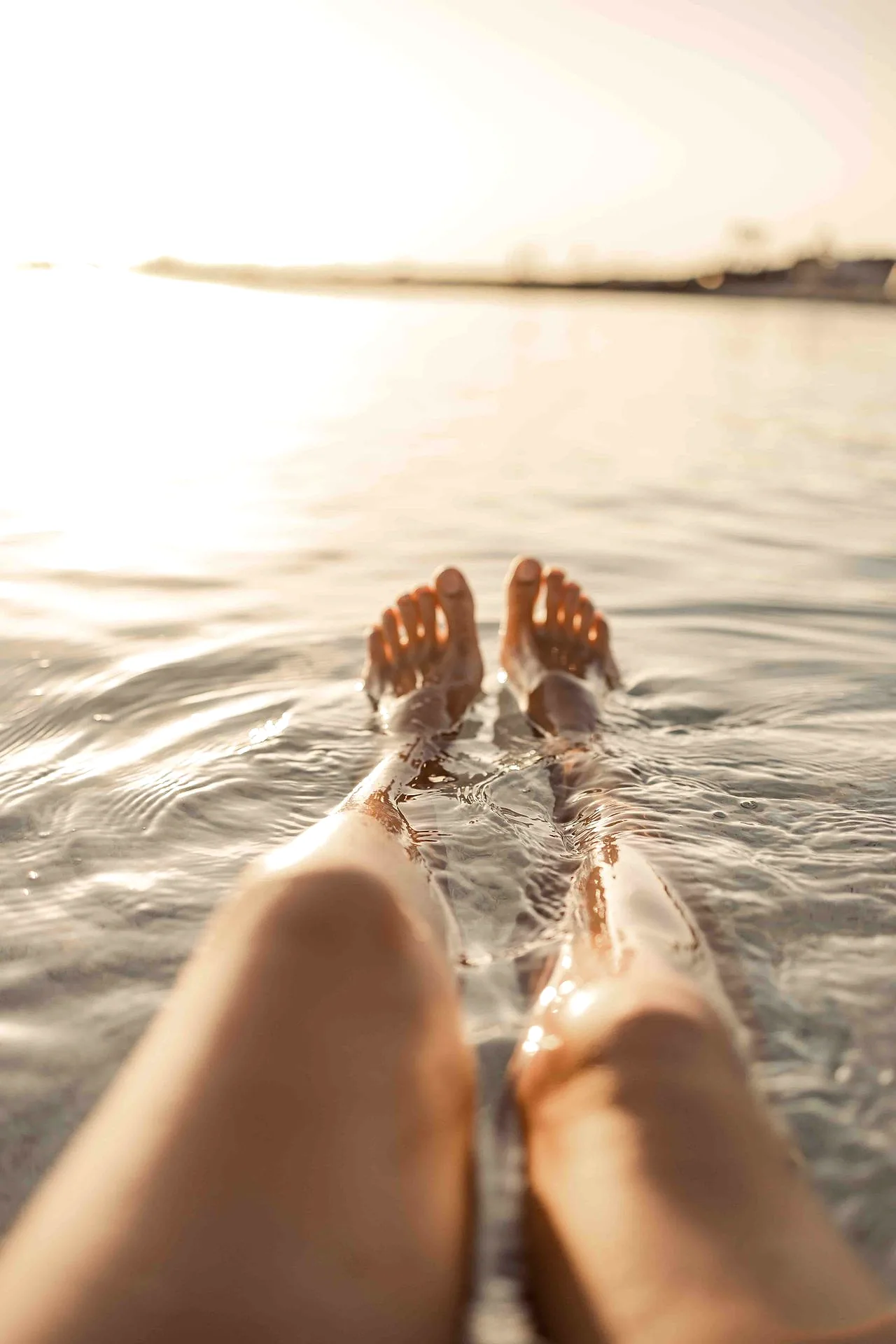 Clear shallow water over pale sand, the sea running flat to the horizon.