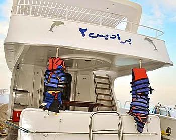 The after deck of Paradise 2, life jackets stowed along the rail and her name lettered above.
